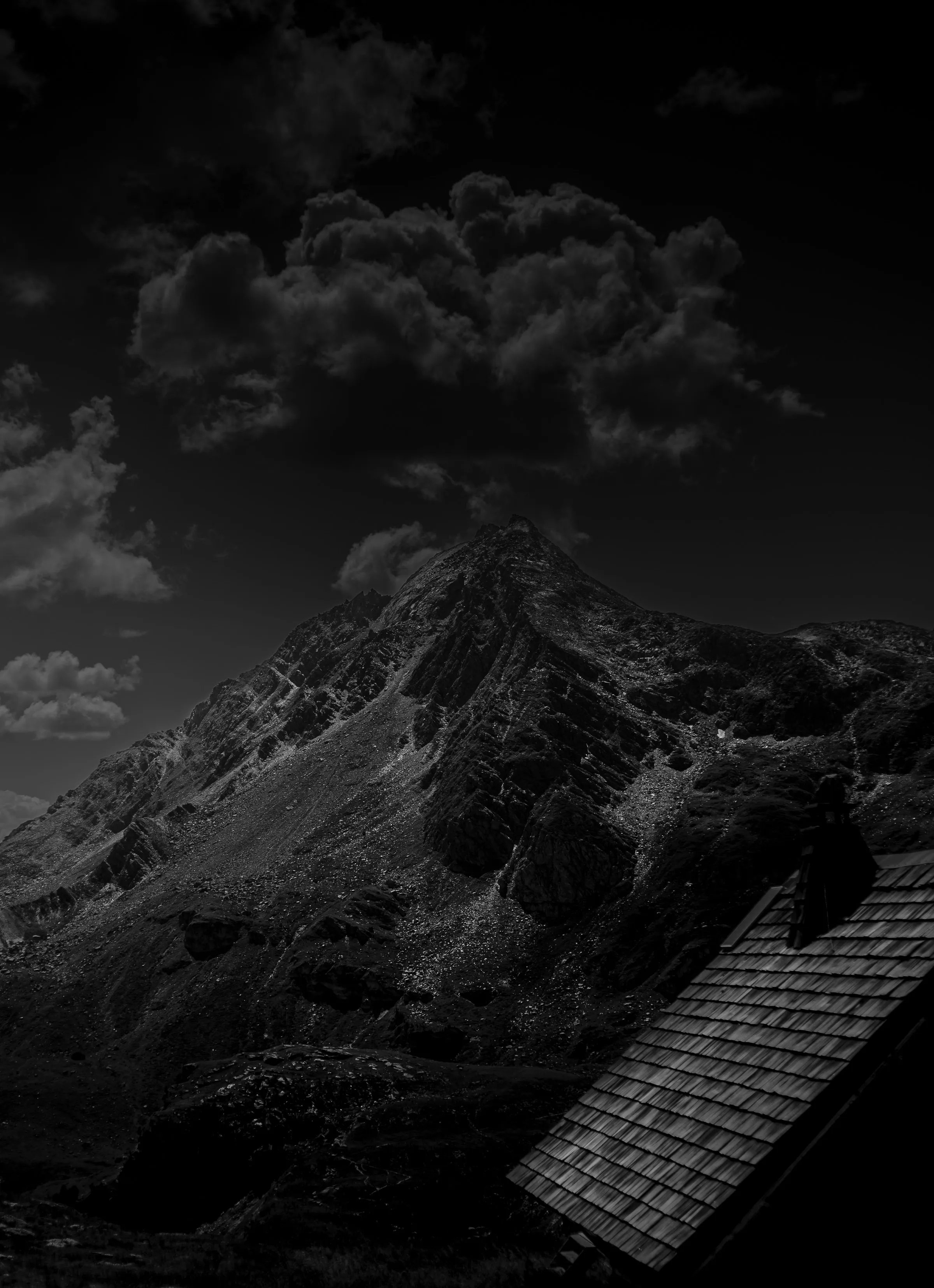 Photographie de paysage alpin — massif montagneux imposant sous un ciel dramatique